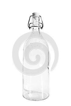 Empty glass bottle with dew drops, isolated on white background