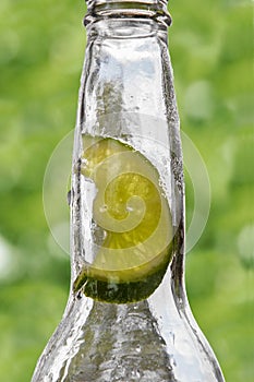 Empty glass bottle with lime inside the neck