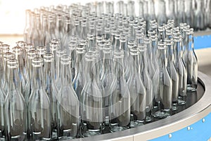 Empty  glass bottles on conveyor belt in factory or glass manufacture