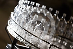 Empty glass bottles on the conveyor. Factory for bottling alcoholic beverages