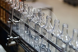 Empty glass bottles on the conveyor. Factory for bottling alcoholic beverages