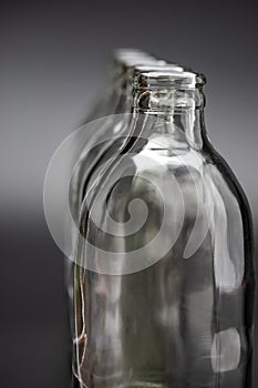 Empty glass bottles in a row on black background