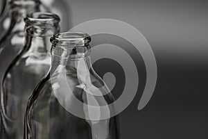 Empty glass bottles in a row on black background