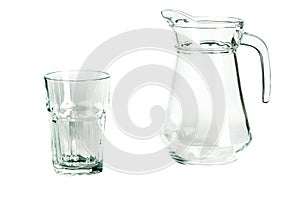 An empty glass glass and a carafe for water stand on a white background