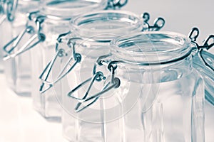 Empty glass food storage jars with a clip top seal isolated.