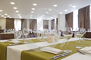 Empty glass goblets and cutlery on green napkin on table