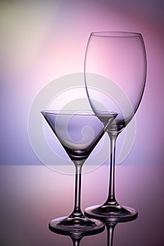 Empty glass goblets set. On a colored purple background abstract