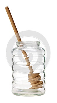 Empty glass honey jar with dipper isolated.