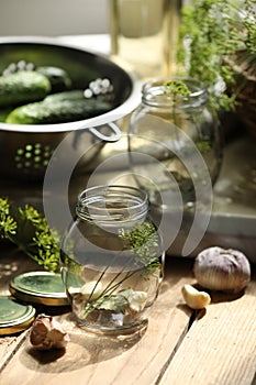 Empty glass jar and ingredients prepared for canning on wooden table
