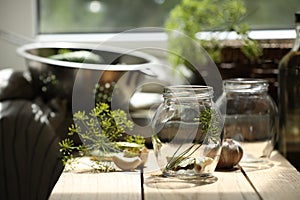 Empty glass jars and ingredients prepared for canning on wooden table indoors