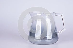 Empty glass jug on grey background