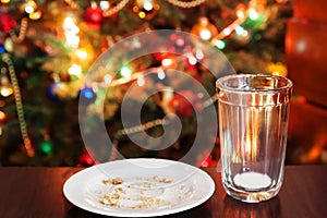 empty glass from milk and crumbs from cookies for Santa Claus un