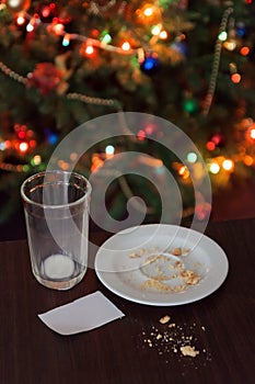 empty glass from milk and crumbs from cookies for Santa Claus un