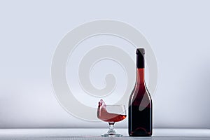 Empty glass, red glass with wine bottle