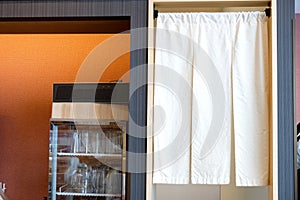 Empty glass in refrigerator cooler with banner hangs at the kitchen entrance