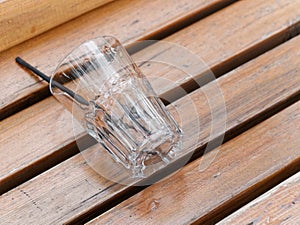 empty glass on top a wooden bench
