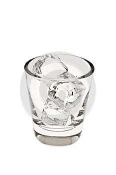 Empty glass tumbler with ice on a white background