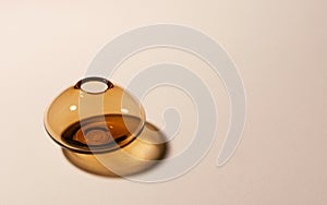 Empty glass vase on beige background with hard long shadows