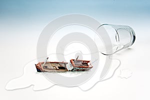 Empty glass of water with Boat capsized (surreal concept)