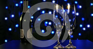 Empty glasses and bottle of champagne on the blue boke background