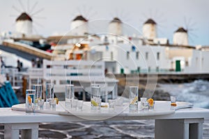 Empty glasses of drinks and cocktails in front of the famous windmills of Mykonos