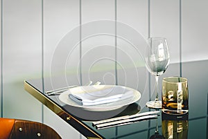 Empty glasses, plate, fork, knife on the table served for dinner in the restaurant