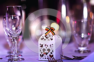 Romanian holiday decorations in restaurant. Empty glasses set with Romanian symbol of tricolor and bokeh background.