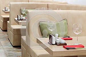 Empty glasses on tables and beige leather sofas