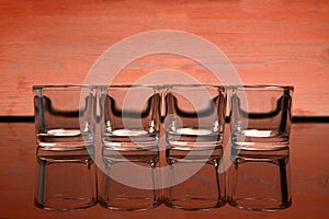 Empty glasses of vodka on a orange background