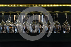 Empty glasses for wine above a bar rack in restaurant