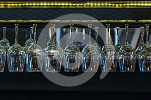 Empty glasses for wine and beverage above a bar rack in restuarant