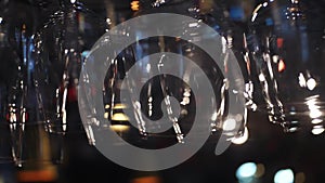 Empty glasses for wine and other alcoholic drinks hanging over the bar counter. Frame. Blurred view of wine glasses