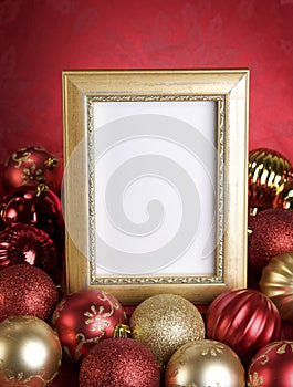 Empty Gold Frame with Christmas Ornaments on a Red Background