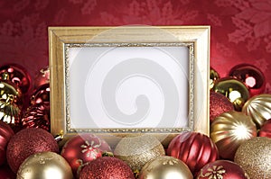 Empty Gold Frame with Christmas Ornaments on a Red Background