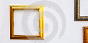 Empty gold, golden or yellow picture frame mock up on white concrete wall with copy space for add or fill text.