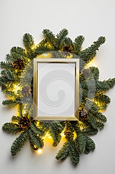 Empty golden border with garland of fir branches and lights on a white background
