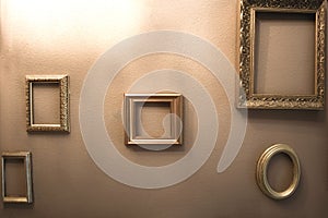 Empty golden luxury frames on vintage design wall, space for text. antique luxe interior