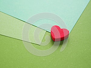 Empty gradient green colored paper with red heart background texture. Abstract geometric flat composition.