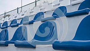 Empty grandstand with blue and white seats outdoors