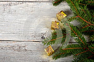 Empty Gray wooden board background with green spruce branches on one side and gift boxes.