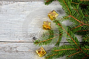 Empty Gray wooden board background with green spruce branches on one side and gift boxes.