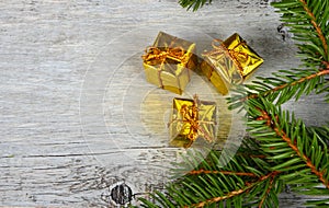 Empty Gray wooden board background with green spruce branches on one side and gift boxes.