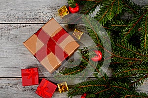 Empty Gray wooden board background with green spruce branches on one side and gift boxes.