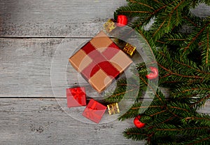 Empty Gray wooden board background with green spruce branches on one side and gift boxes.