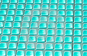Empty green plastic chairs in a row at the football stadium