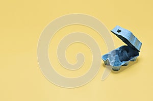 Empty half dozen egg carton container on yellow