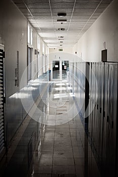 Empty hallway corridor of a high school or college closed during COVID-19 Coronavirus. Locers blurred into lonley hallway