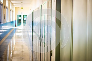 Empty hallway corridor of a high school or college closed during COVID-19 Coronavirus. Locers blurred into lonley hallway