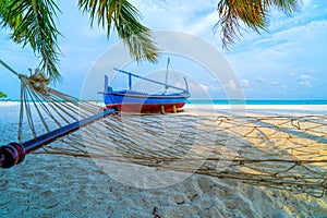 Empty hammock between palms trees at sandy beach