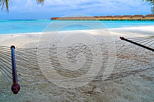 Empty hammock between palms trees at sandy beach